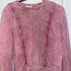 A pink sweater with a marble type pattern (maybe)